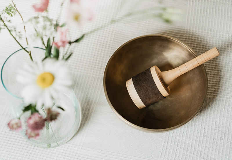 Eine Klangschale und ein Blumenstraus auf einem Tisch dekoriert