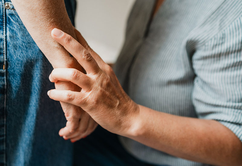 Die Therapeutin hält die Hand der Klientin um das Signal aufzuspüren